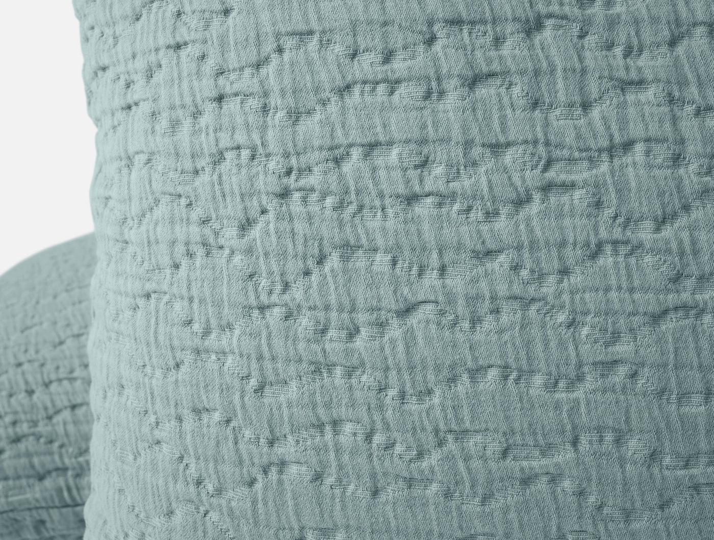Close-up of seafoam matelassé texture on Pescadero pillow sham corner.