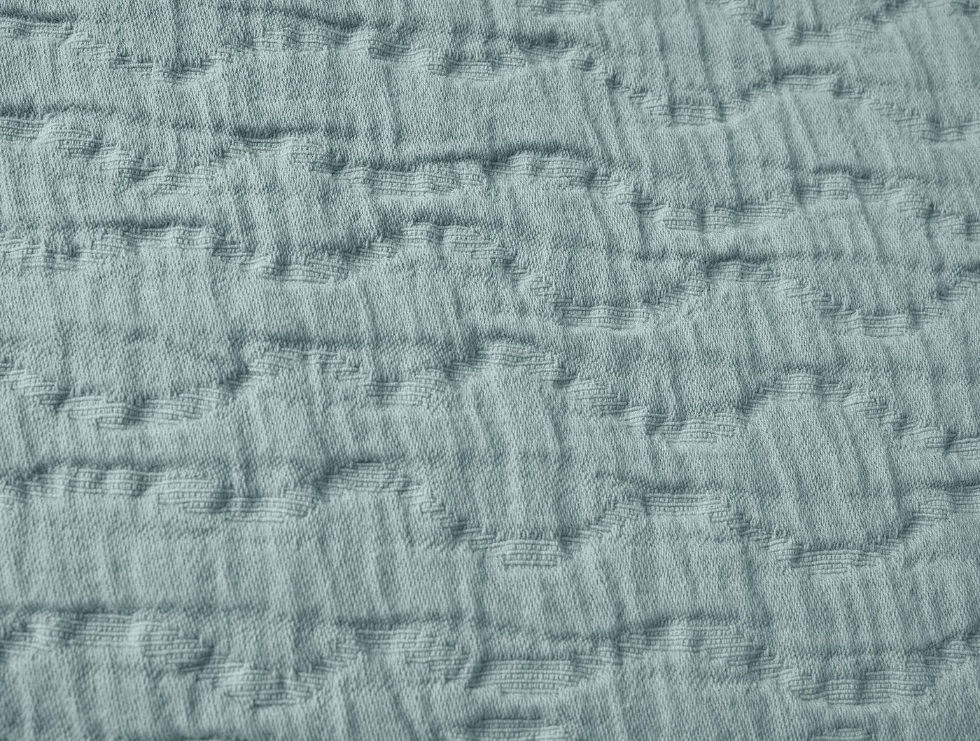 Close-up of sage matelasse weave texture on Coyuchi Pescadero pillow sham.