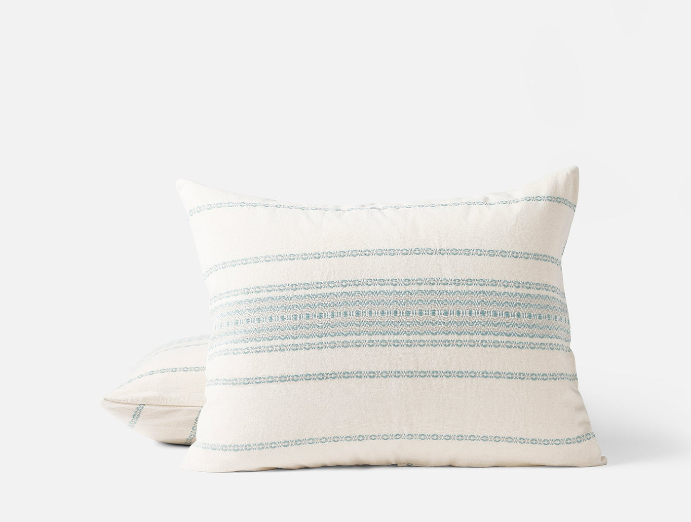 Close-up of two stacked Coyuchi Rippled Stripe shams in ivory with blue horizontal embroidered stripes.