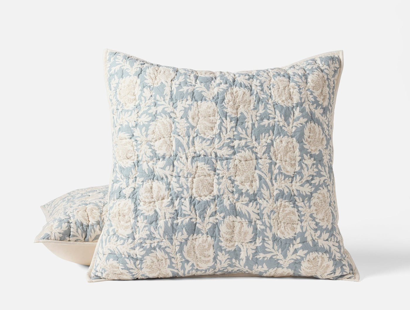 Two Coyuchi Robles shams stacked, dusty blue block-print floral pattern on quilted linen.