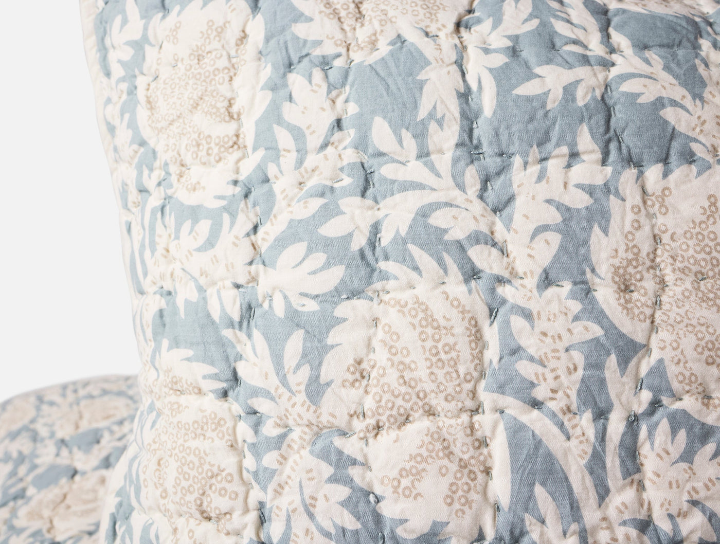 Close-up of Coyuchi Robles Handstitched sham in sky blue with ivory floral block print and quilted stitching.