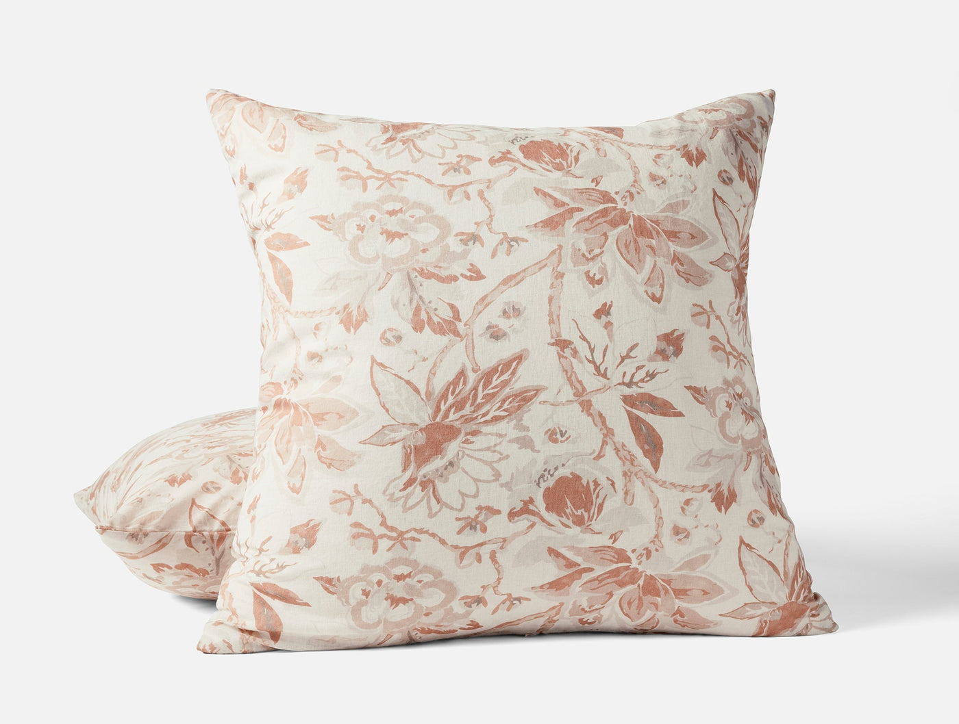 Coyuchi Sea Bloom ivory pillow shams with dusty rose floral print, stacked and styled.