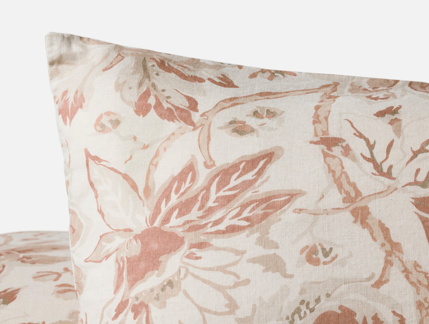 Close-up corner of Coyuchi Sea Bloom Print sham in blush floral pattern on ivory linen.