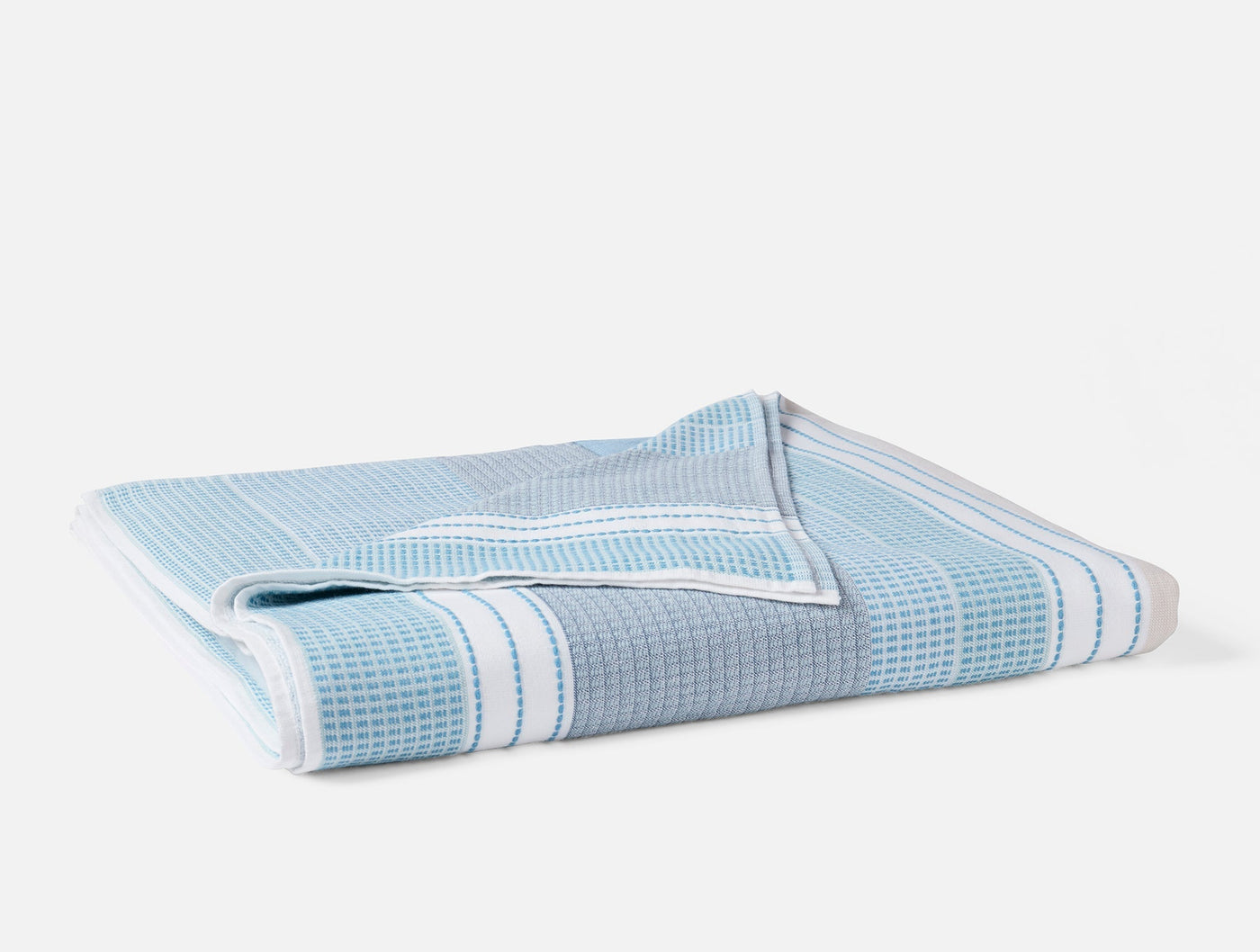 Folded sky blue waffle-weave beach towel with white stripe border detail.