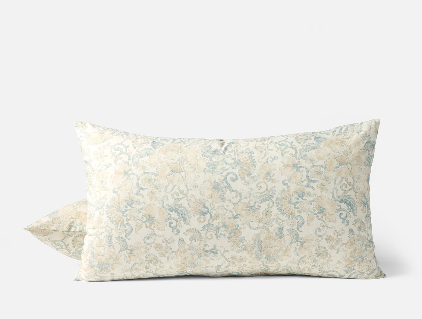 Pair of Coyuchi Solana Print shams in ivory with soft blue and gold floral pattern.
