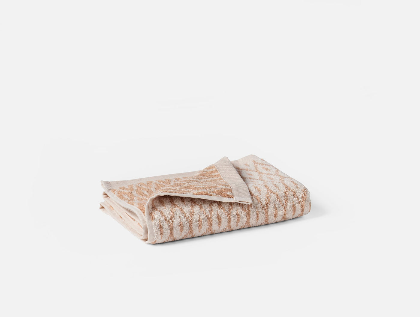 Folded sand and ivory jacquard hand towel, reverse side visible showing plain weave.