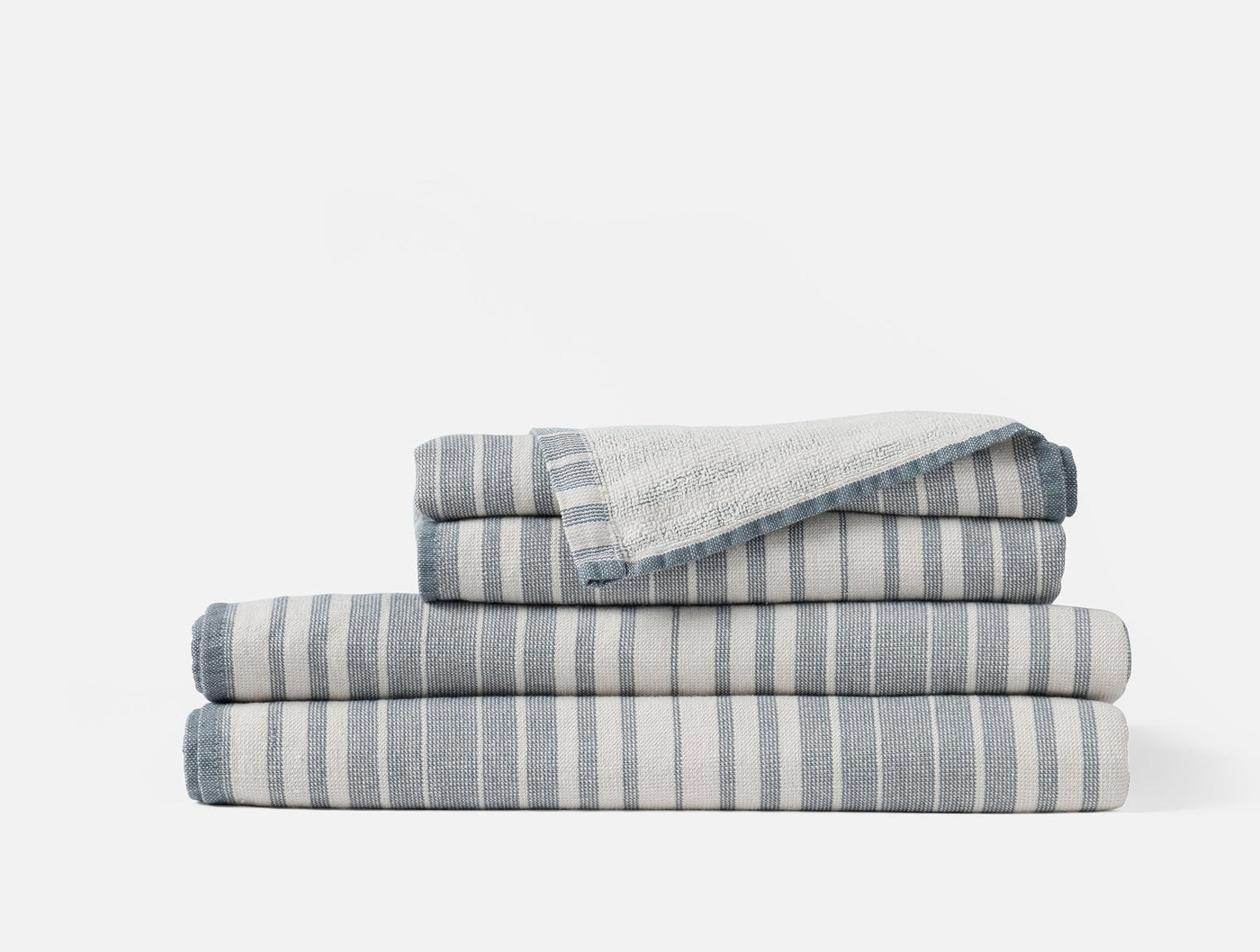 Coyuchi Sycamore Cotton Linen hand towel in blue and ivory stripe, folded stack.