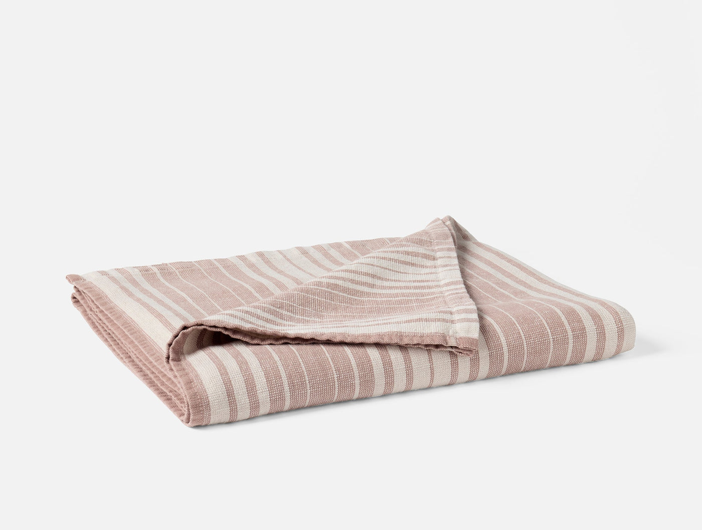 Folded blush and ivory striped cotton linen bath towel, corner detail visible.