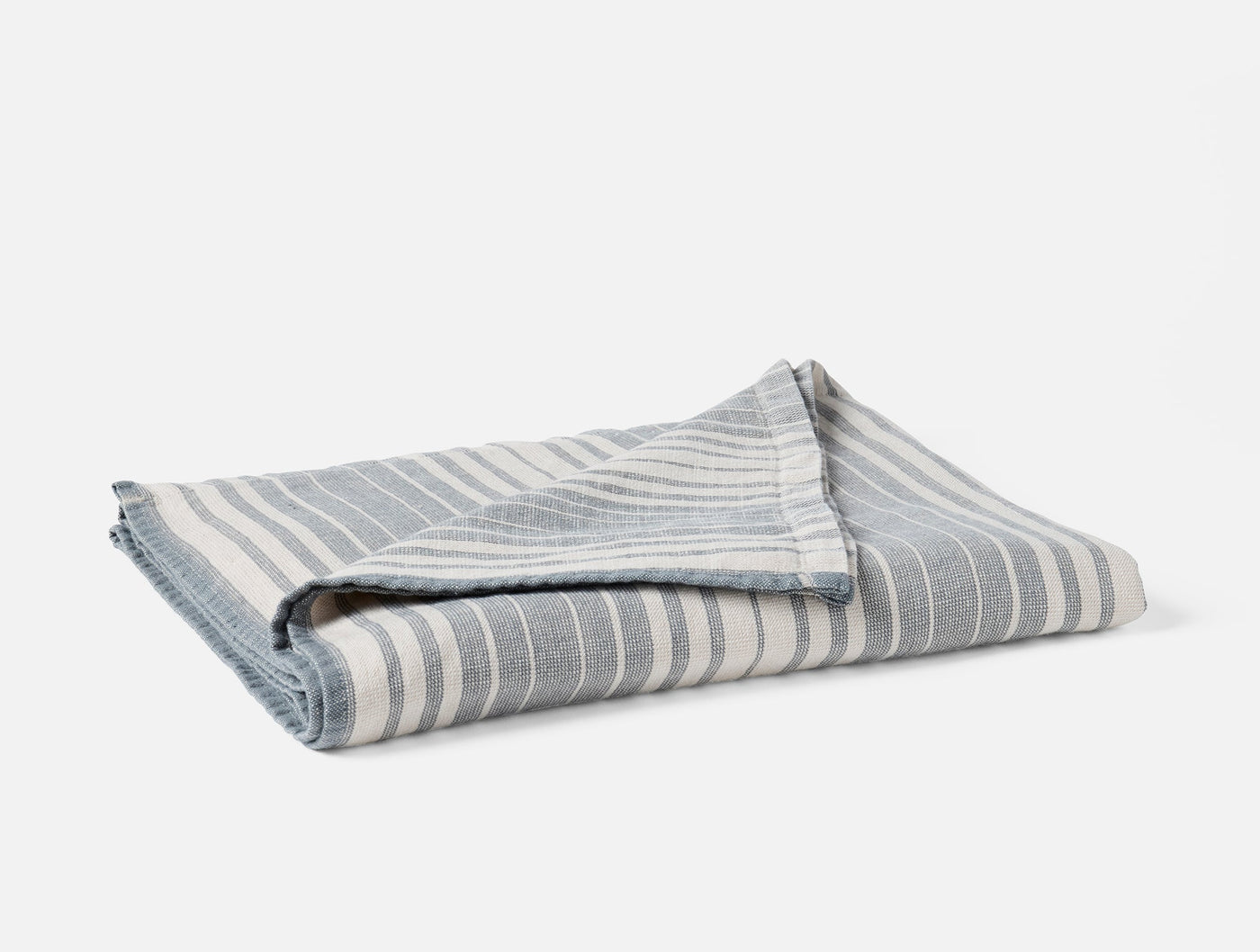 Folded Coyuchi Sycamore hand towel showing slate blue and ivory stripe pattern.