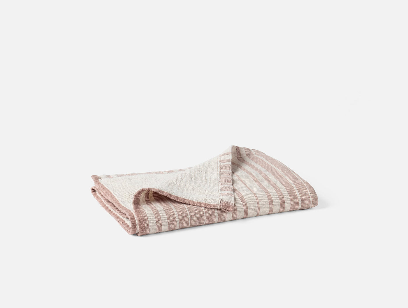 Folded blush and ivory striped cotton linen bath towel, corner detail visible.