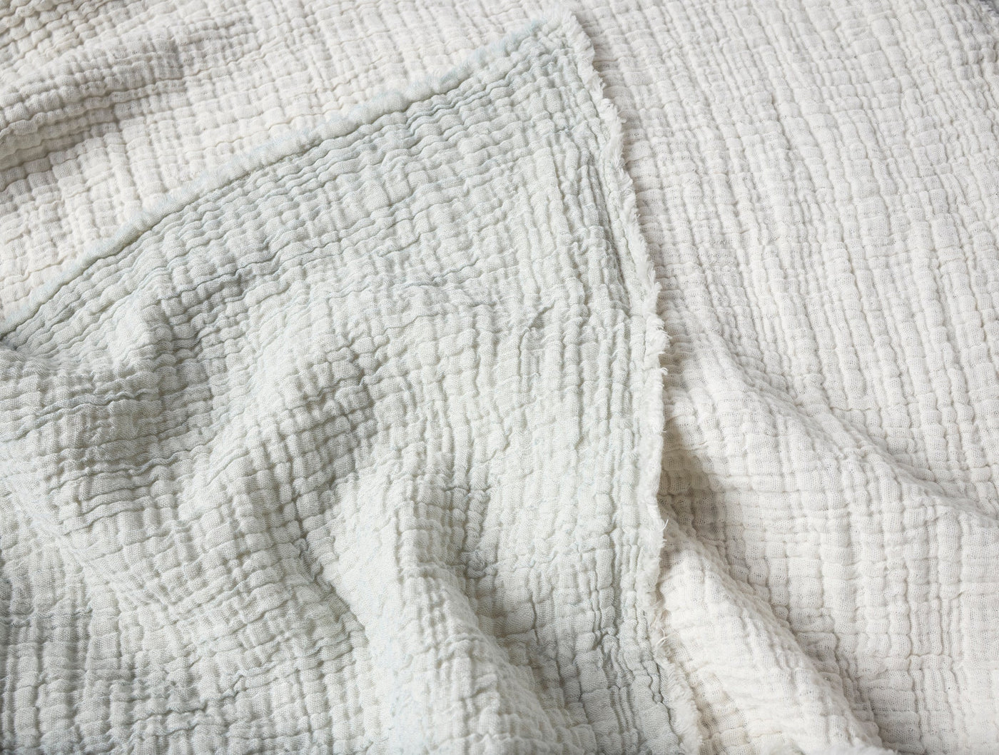 Close-up of ivory crinkled matelassé weave texture on Coyuchi Topanga blanket.