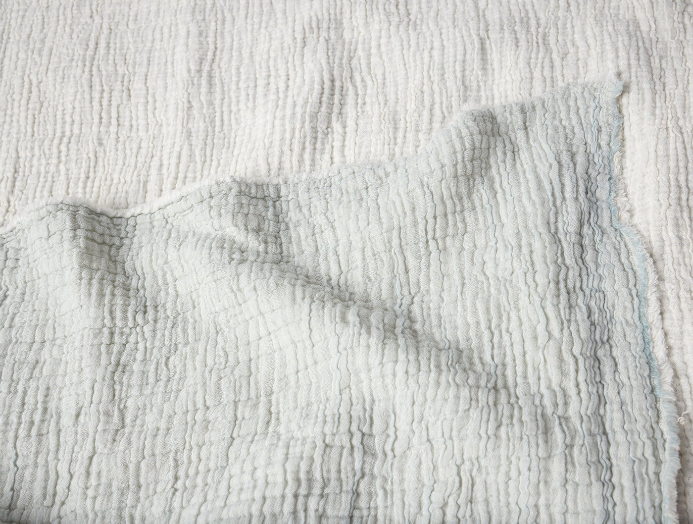 Close-up of Coyuchi Topanga Matelassé throw in white, showing crinkled ripple texture.