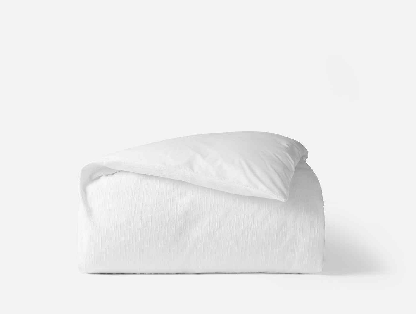 Coyuchi Toro Canyon duvet cover in white, folded to show subtle stripe texture.