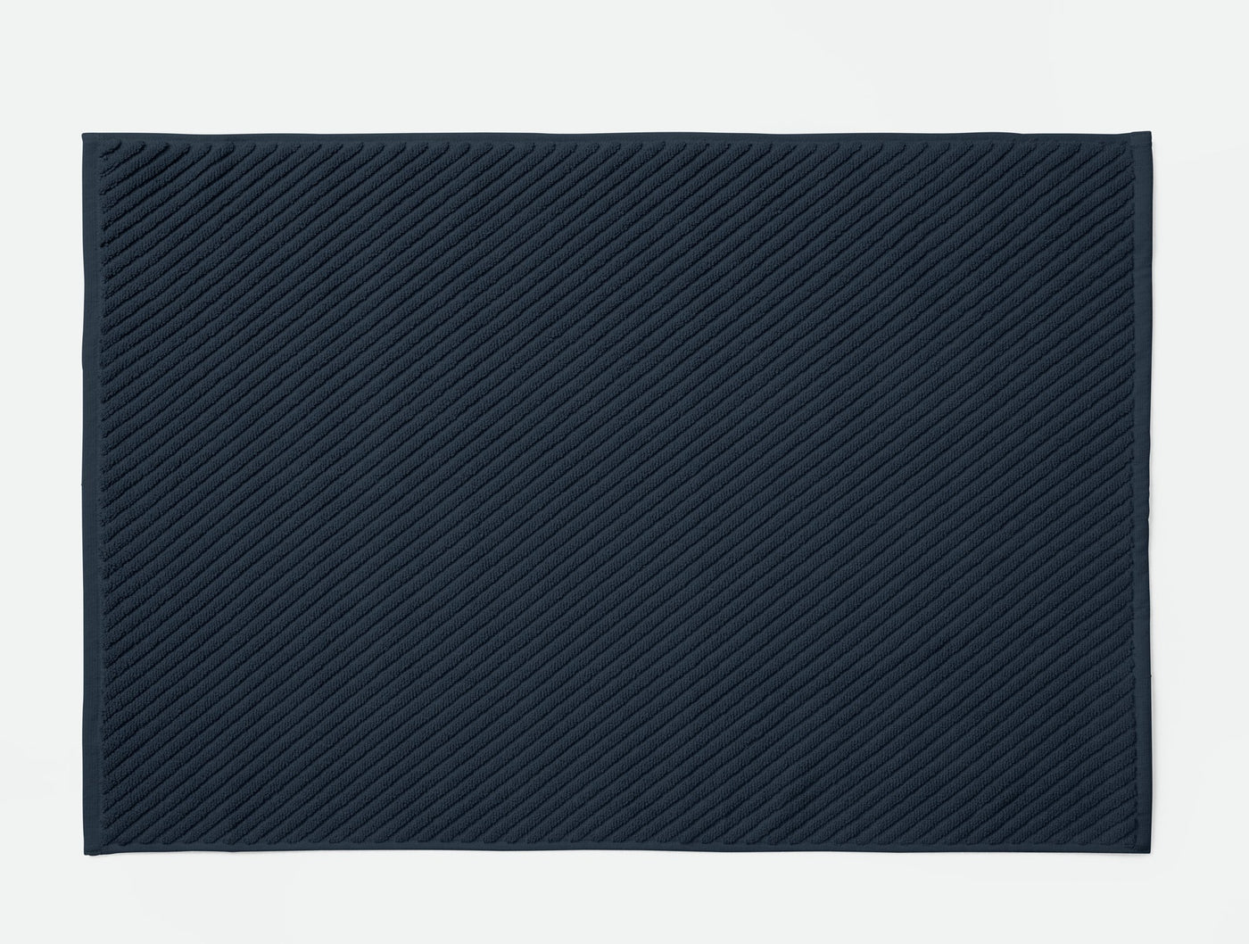 Coyuchi Air Weight bath rug in navy, showing diagonal twill weave texture detail.