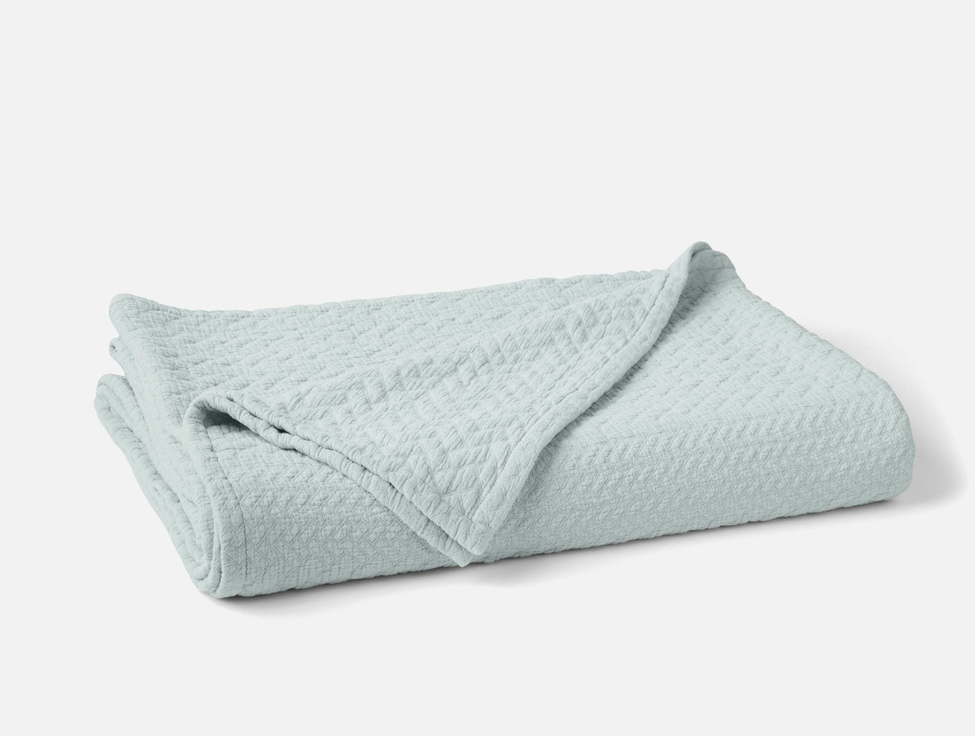 Coyuchi Angeles Matelasse blanket in seafoam, folded to show woven chevron texture.