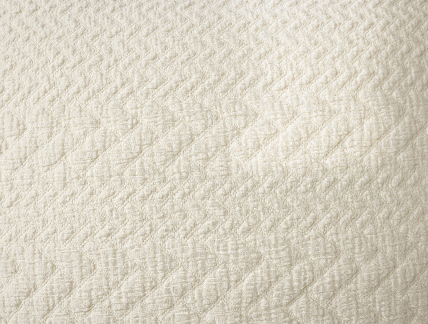 Close-up of ivory matelassé weave texture on Coyuchi Angeles pillow sham.