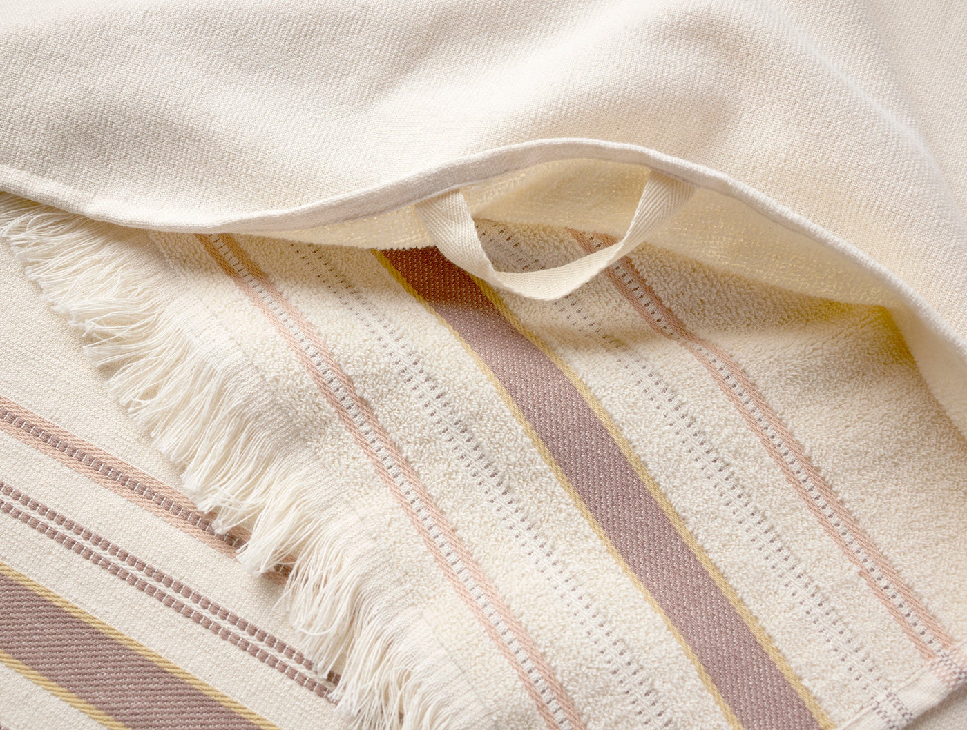 Close-up of Coyuchi Aptos hand towel fringe and multicolor stripe weave detail.
