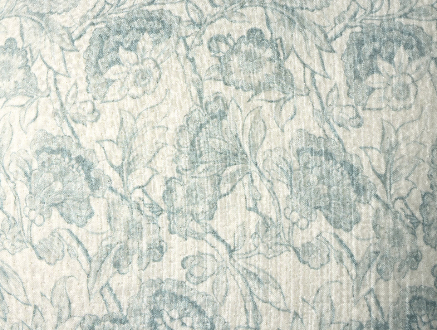 Close-up of Coyuchi Balboa Matelasse Print pillow in dusty blue floral jacquard pattern.