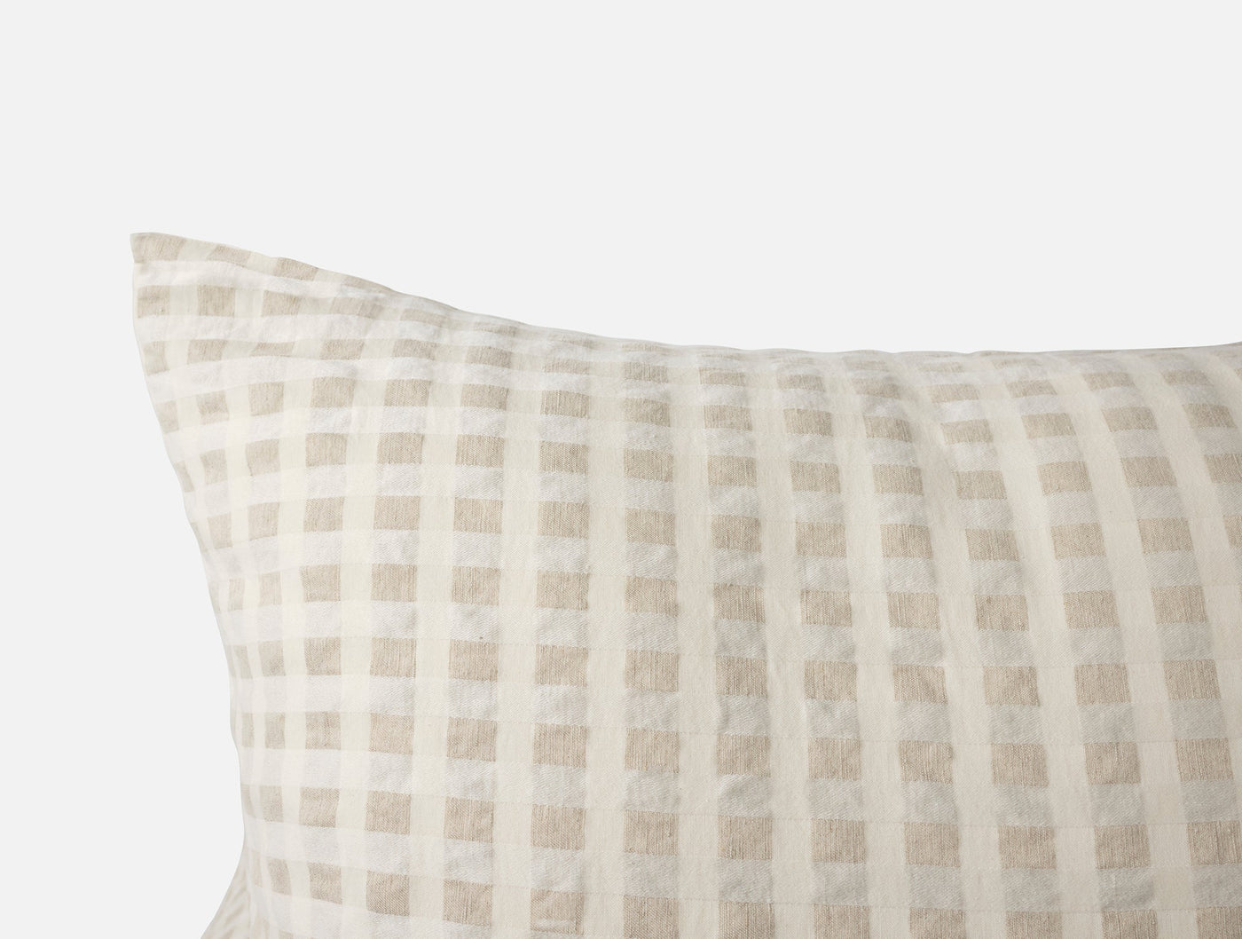 Close-up of Coyuchi Birch sham corner showing woven gingham check in natural and ivory linen.