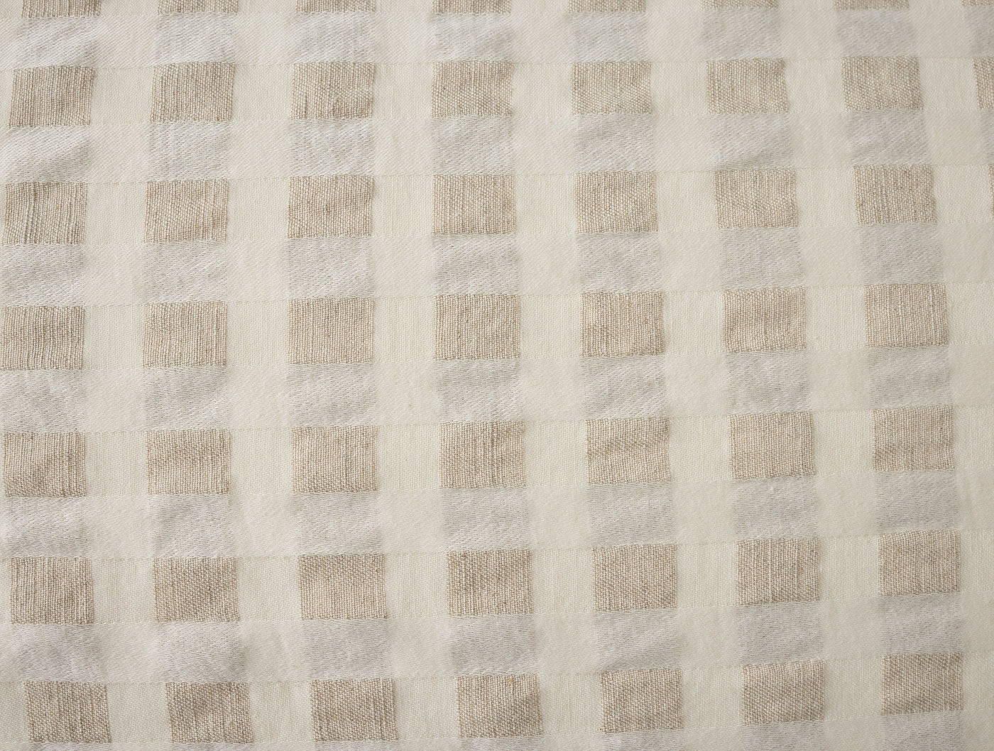 Close-up of Coyuchi Birch sham fabric showing ivory and sand woven gingham texture.