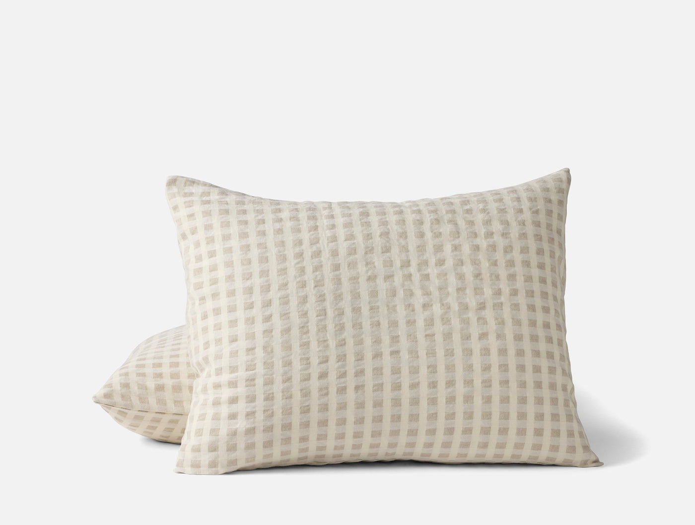 Close-up of two Coyuchi Birch shams stacked, ivory with woven grid texture.
