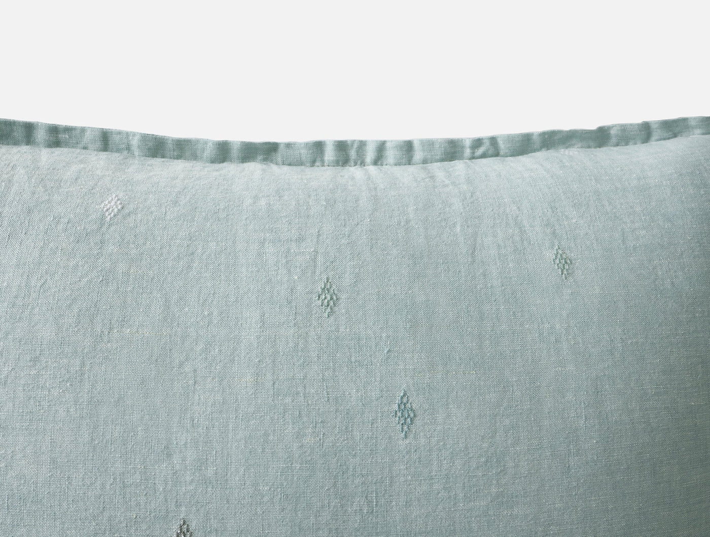 Close-up of Coyuchi Cambria sham in sea foam, showing diamond embroidery and satin-stitched hem.