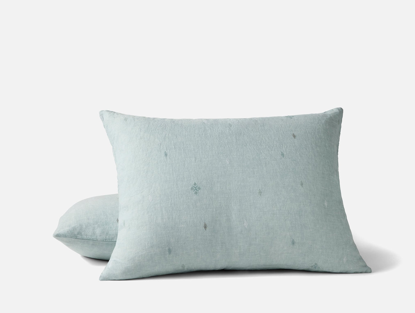 Close-up of two Cambria shams in misty blue linen with subtle embroidered dot motifs.