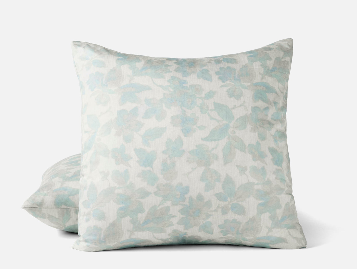 Close-up of Coyuchi Camellia Print sham in soft aqua floral pattern on ivory ground.