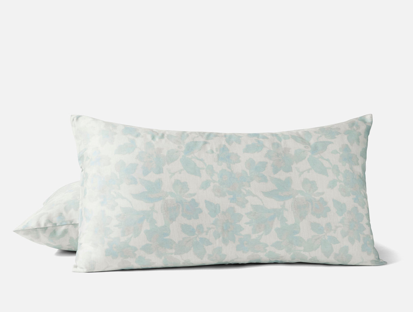 Pair of Coyuchi Camellia Print shams in soft aqua floral pattern on ivory ground.