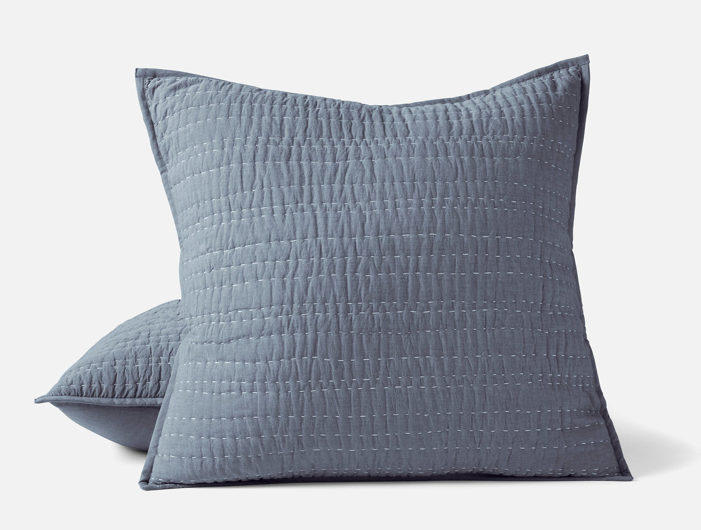 Two slate blue Coyuchi Channel Handstitched shams showing vertical quilted texture detail.