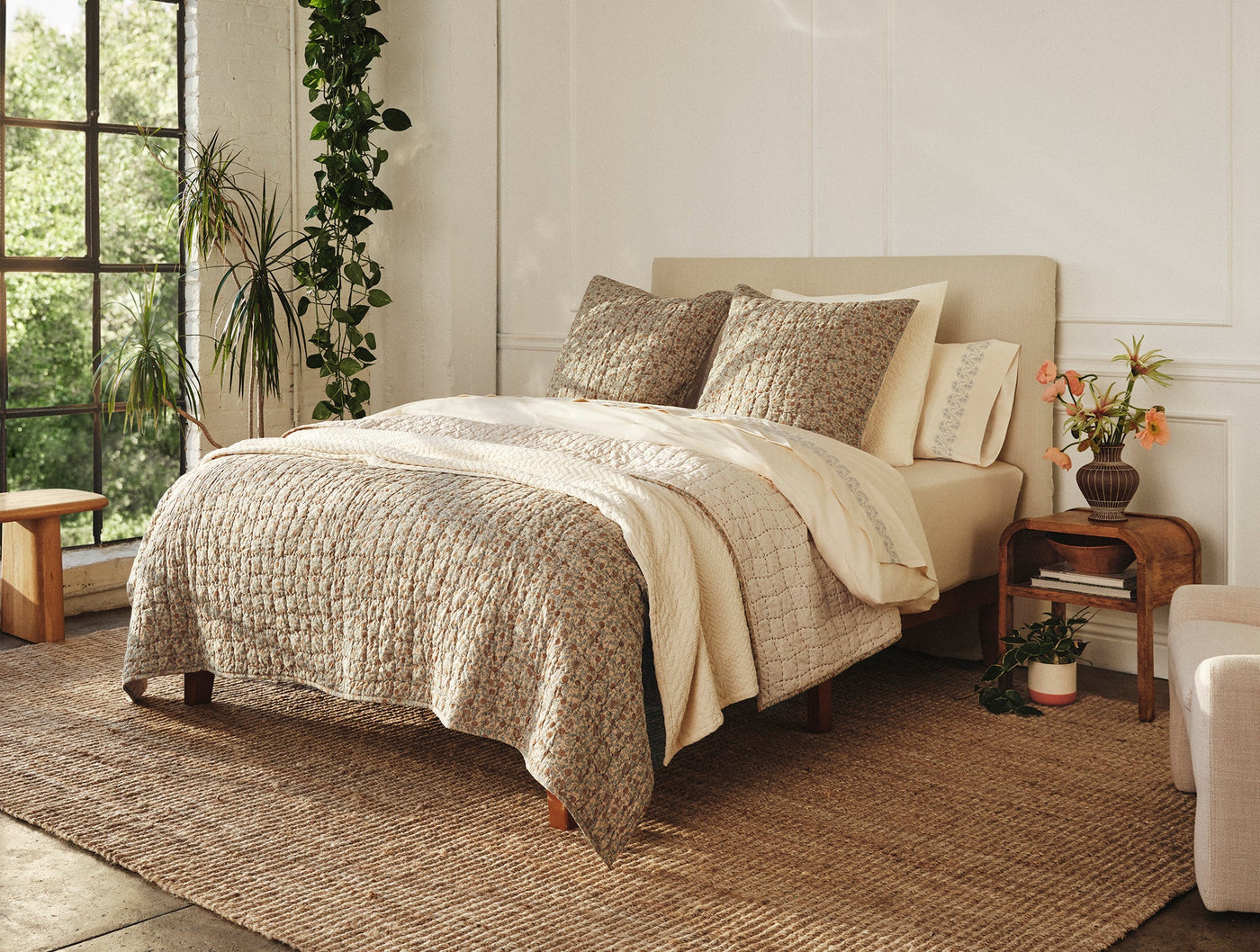 Coyuchi Blossom Handstitched shams styled on bed with matching duvet in natural bedroom.