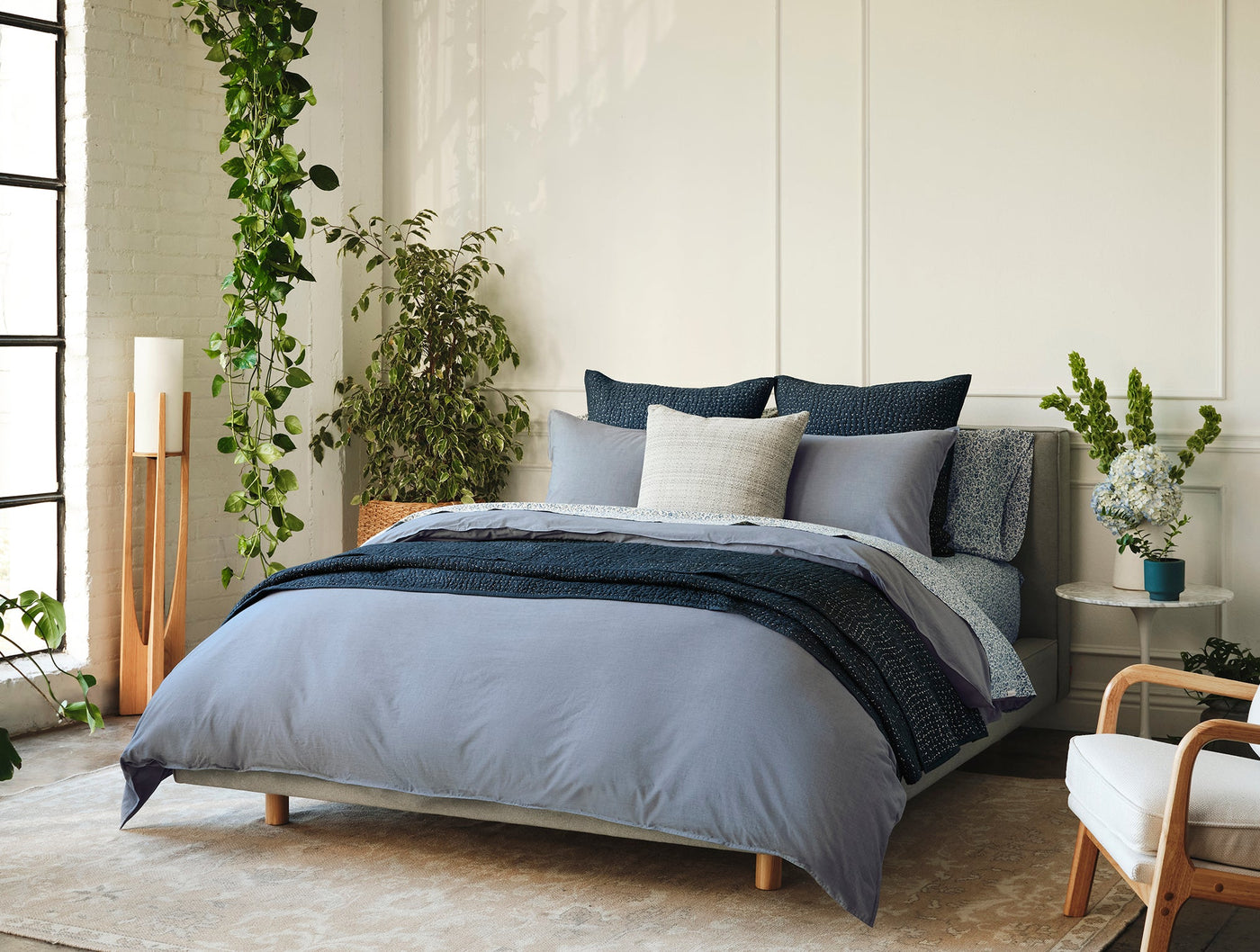 Close-up of Coyuchi Crinkled Percale duvet cover in slate blue, styled with navy accents.