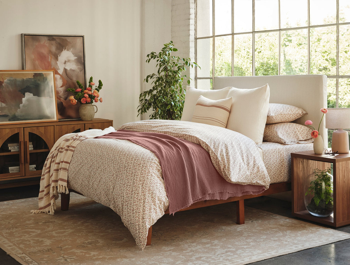 Dusty rose Coyuchi Topanga Matelasse blanket draped across a styled bed.