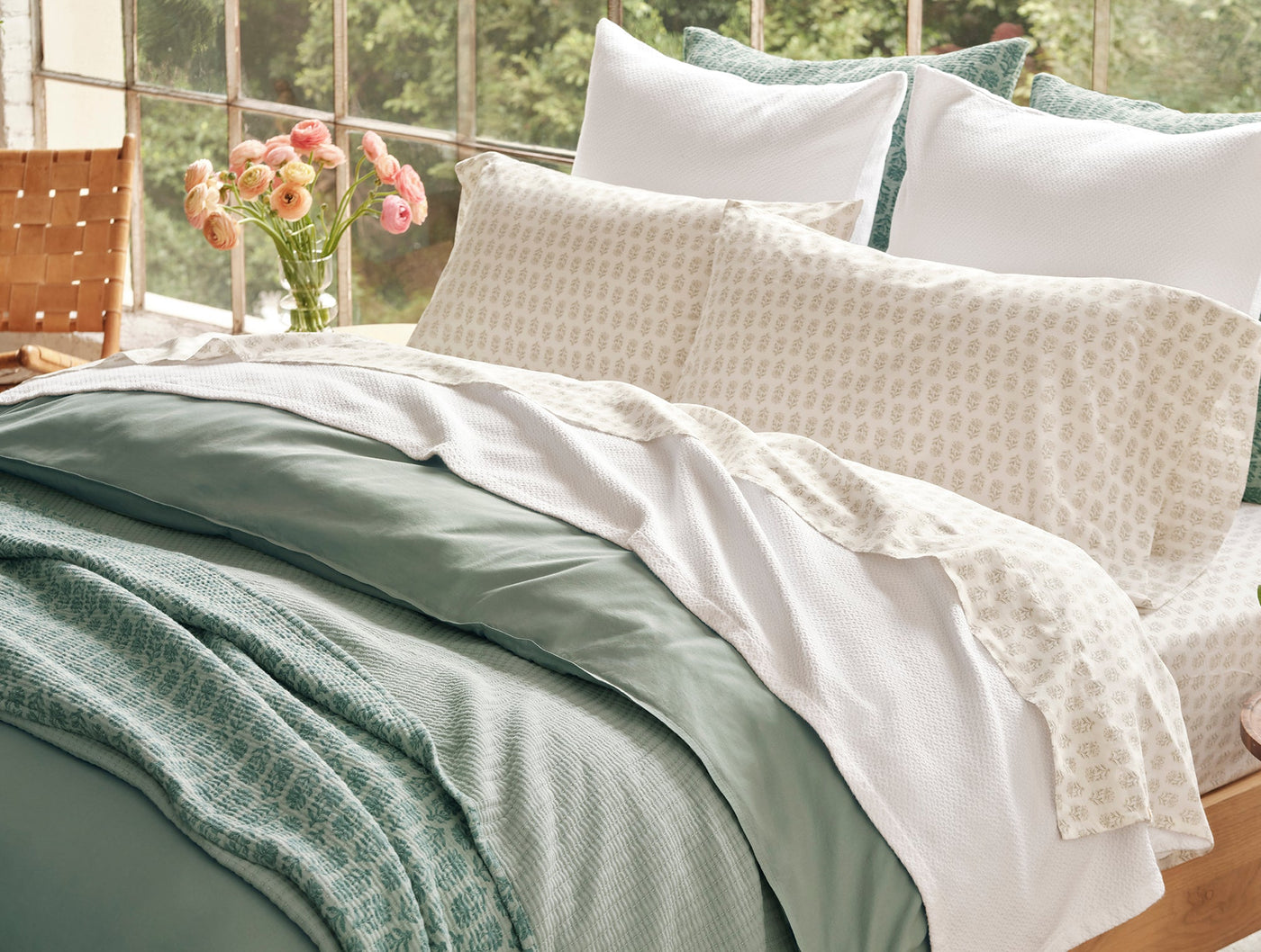 Close-up of Coyuchi Print Percale pillowcases in ivory with subtle geometric print, styled on a bed.