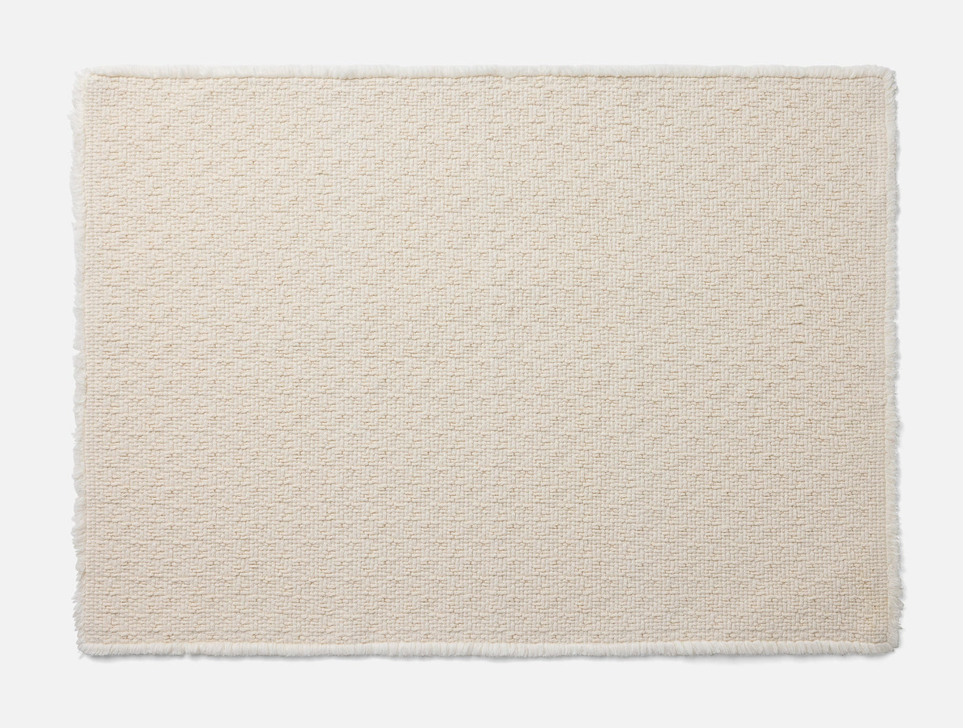 Coyuchi Honeycomb bath rug in ivory, textured honeycomb weave with fringe edges.