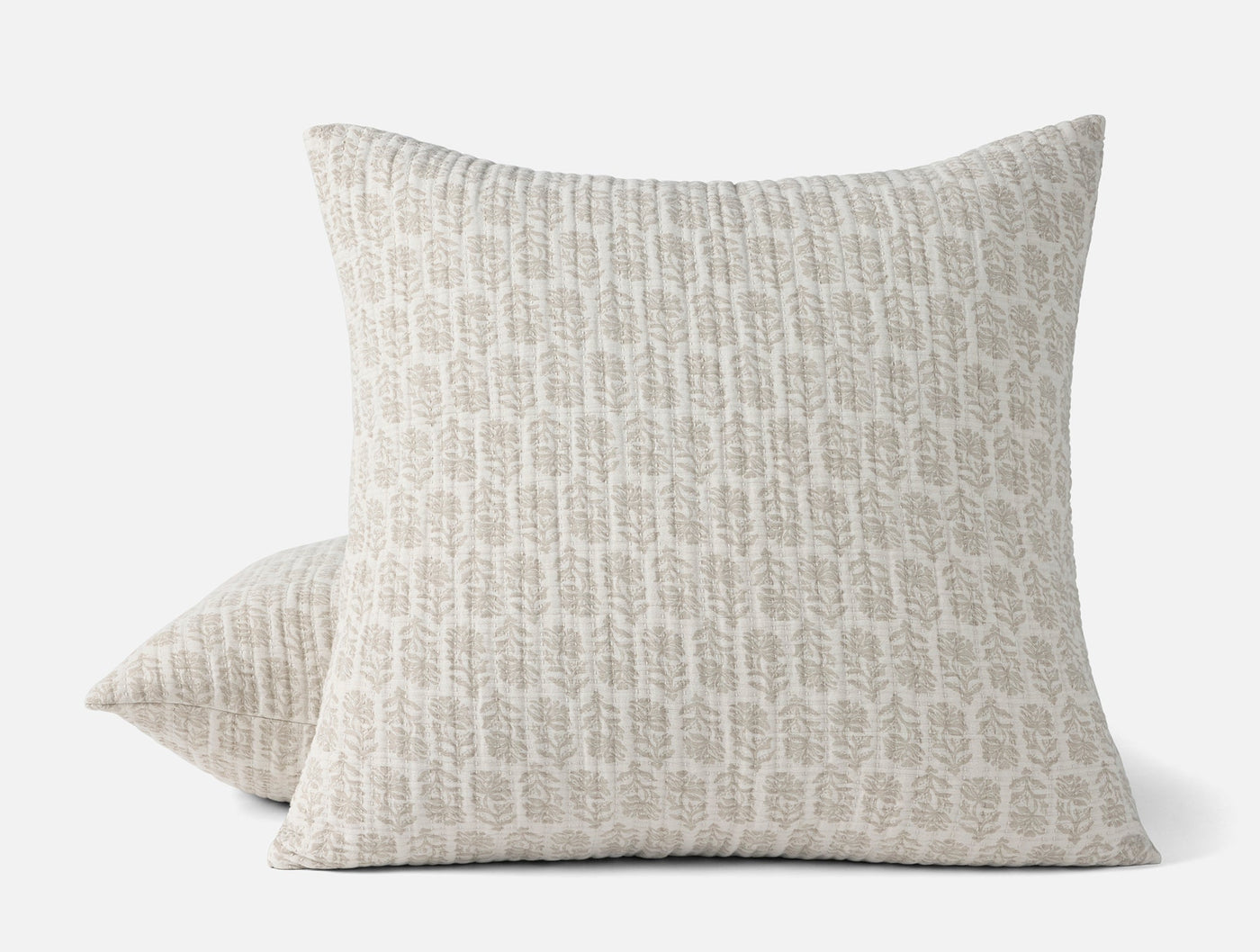 Two Coyuchi Mirada Matelasse shams stacked, ivory with grey botanical print.