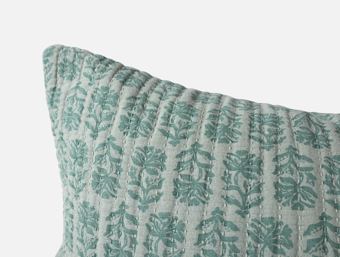 Close-up of teal floral block-print pattern and quilted texture on Coyuchi Mirada Matelasse sham.