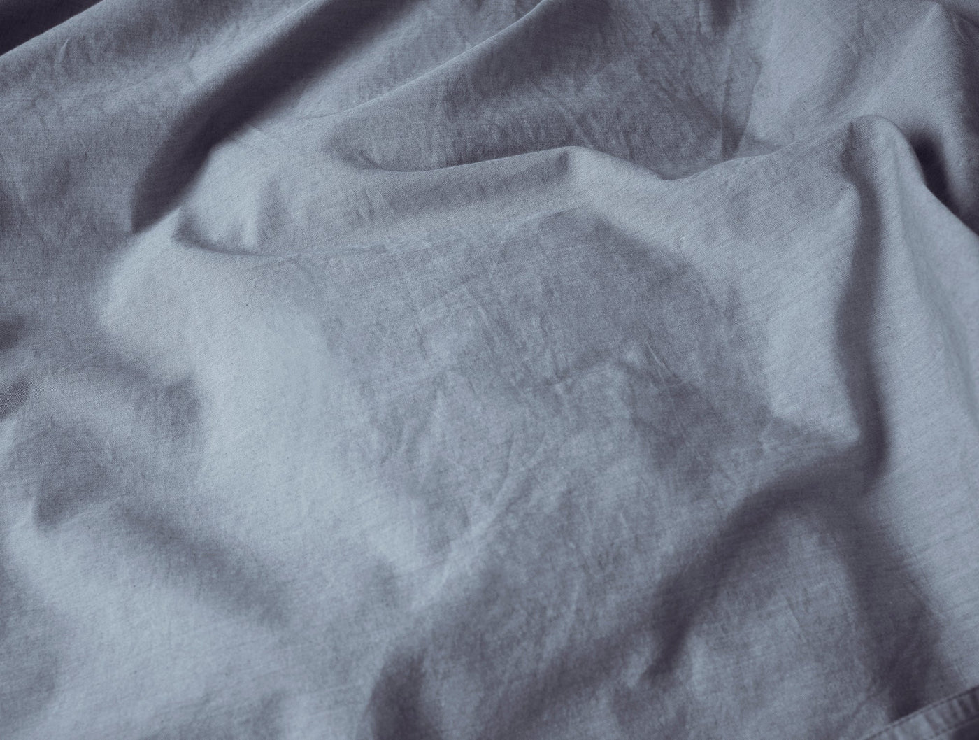 Slate blue crinkled percale fabric with natural soft draping and relaxed texture.