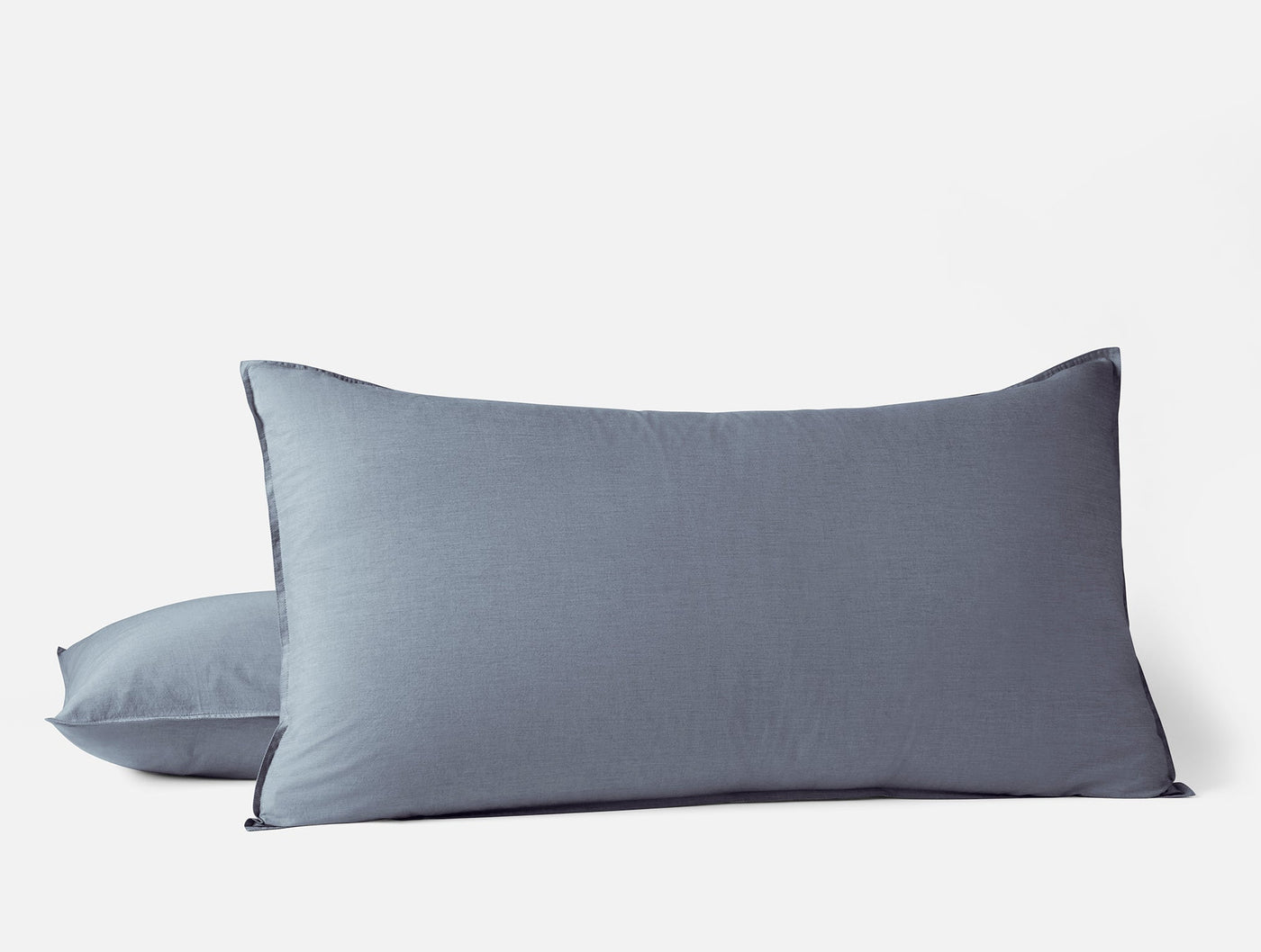 Two slate blue Coyuchi Crinkled Percale shams stacked, king size, against white background.