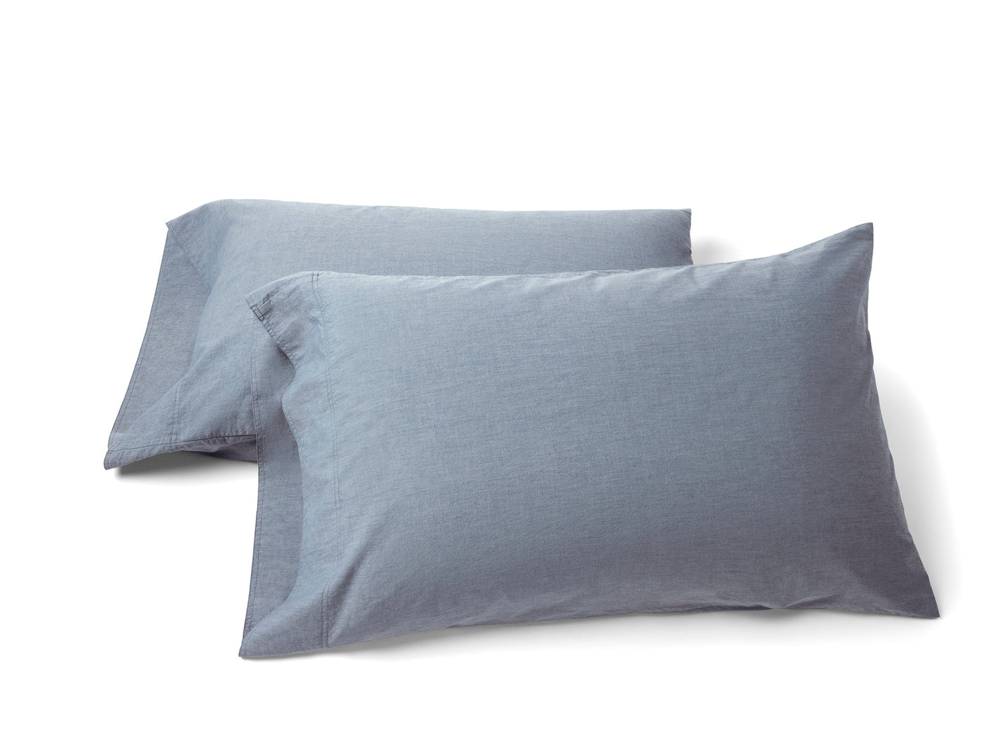 Two slate blue Coyuchi Crinkled Percale pillowcases with subtle texture, stacked on white background.
