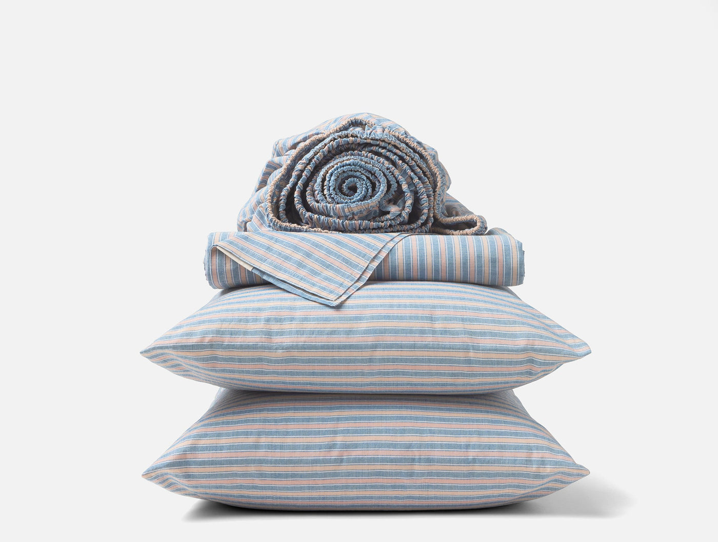 Two blue and white striped percale pillowcases stacked with folded and rolled matching sheets.