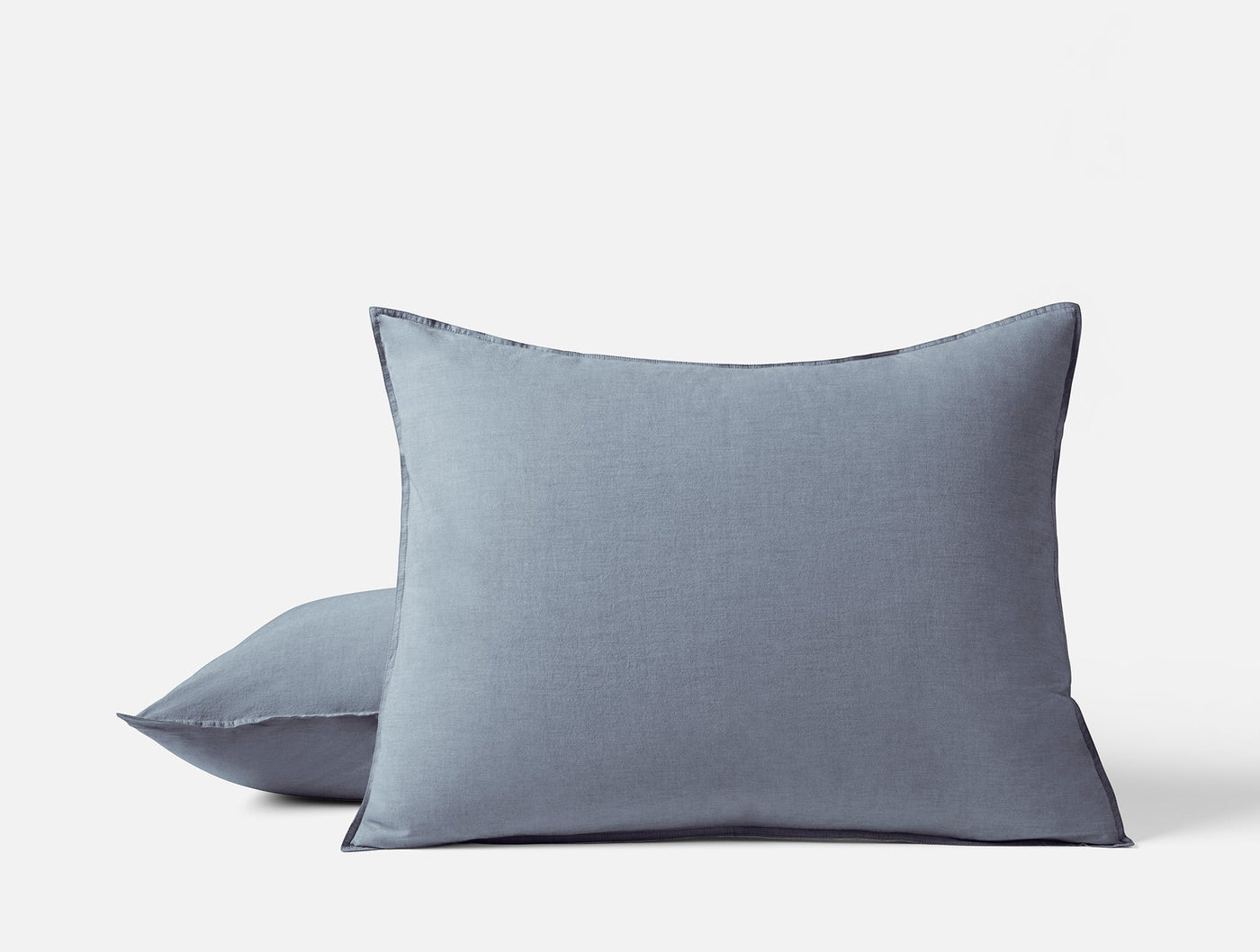 Two stacked Coyuchi Crinkled Percale shams in slate blue with subtle texture detail.