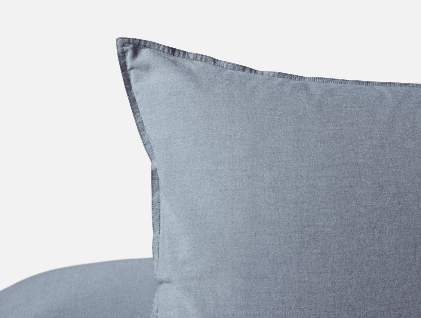 Close-up of Coyuchi Crinkled Percale sham corner in slate blue, showing hem detail.