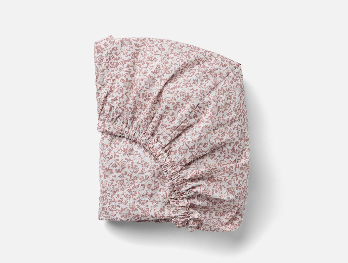 Folded fitted sheet showing elasticized corner detail in rose floral percale print.