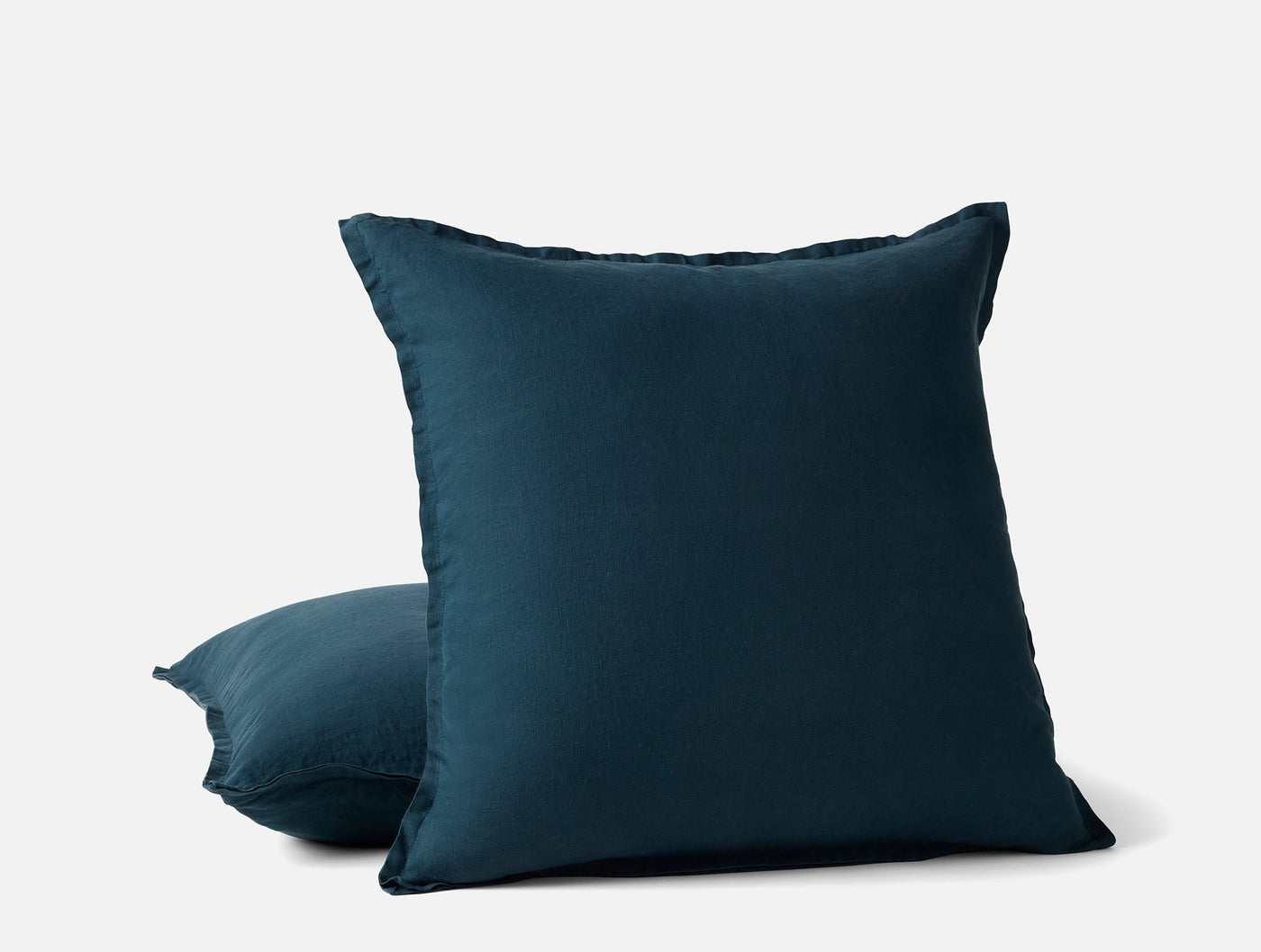 Coyuchi Relaxed Linen pillow covers in deep teal, two stacked, showing frayed edge trim.