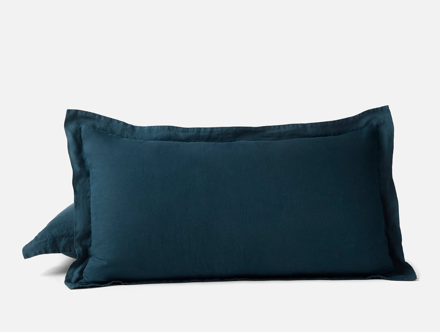 Close-up of two stacked Relaxed Linen shams in deep teal with a flanged edge.