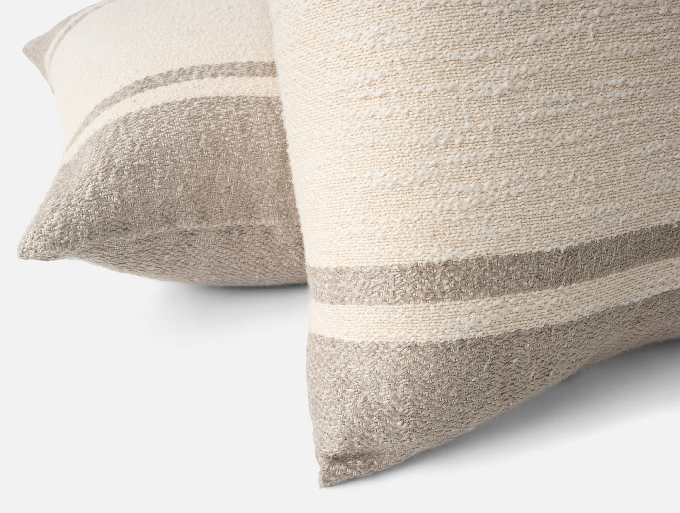 Close-up of two Coyuchi Pampas pillows showing ivory and taupe stripe texture detail.