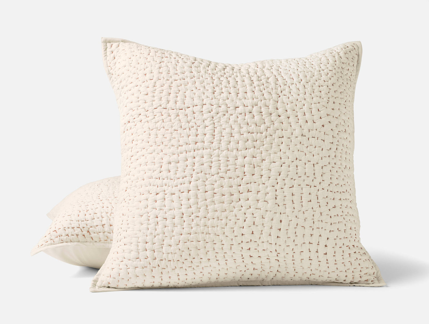 Close-up of Coyuchi Pebbled Handstitched sham in ivory, showing textured grid-stitch pattern.
