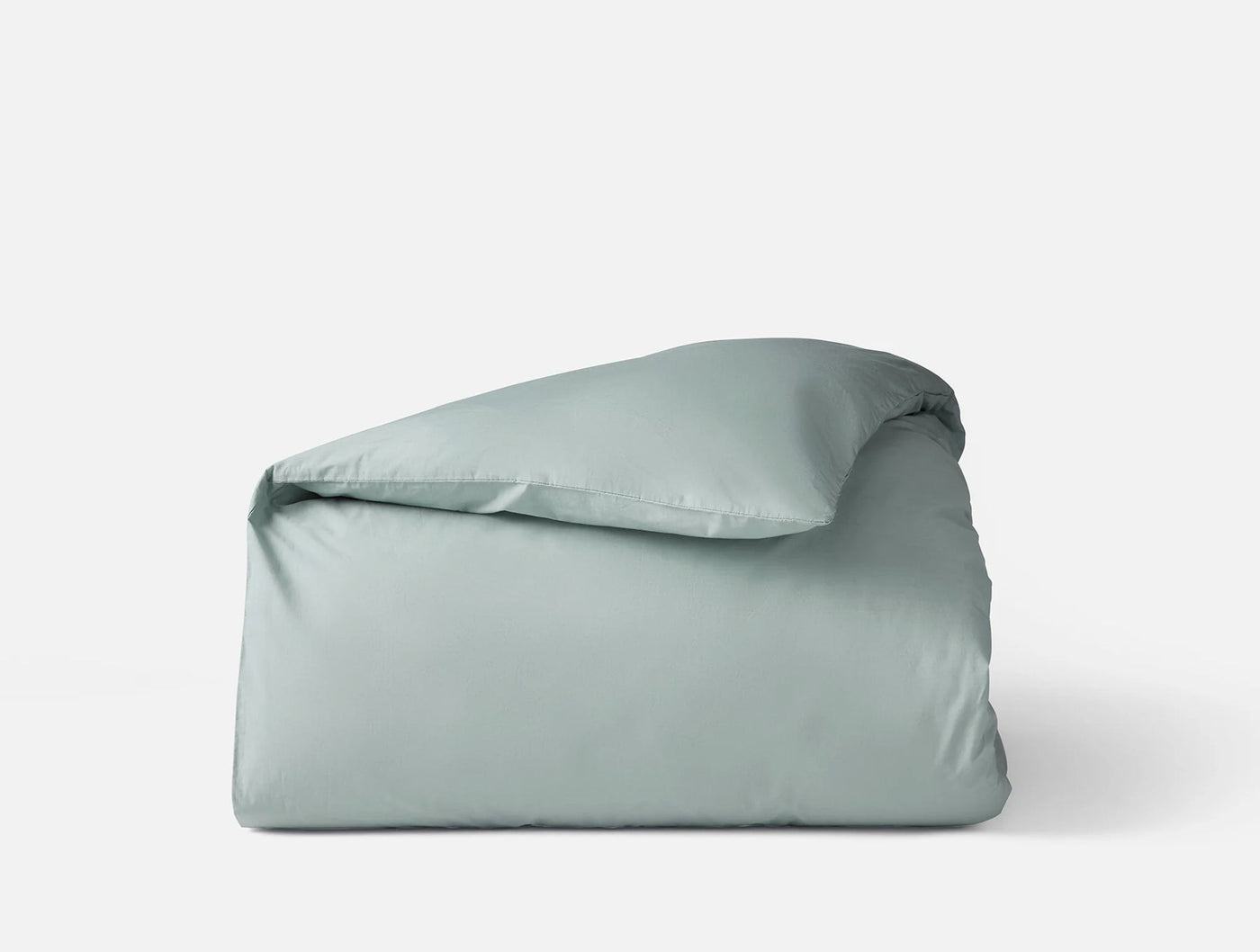 Folded Coyuchi Refined Percale duvet cover in sage, shown from a slight angle.