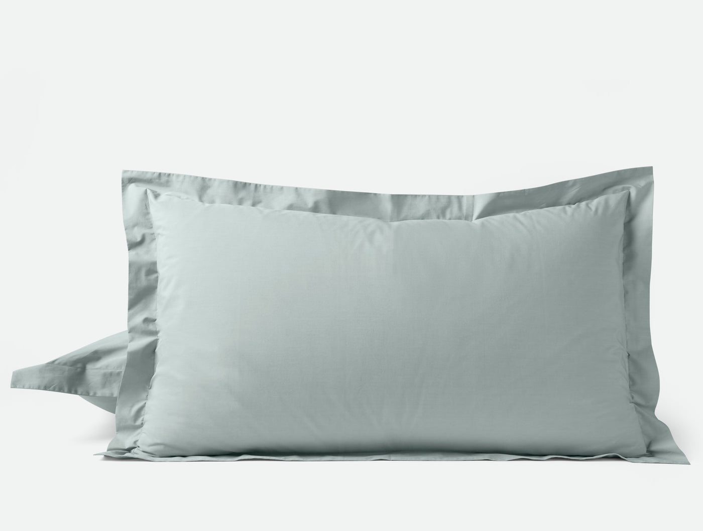 Pair of sage green Coyuchi Refined Percale pillow shams with tailored flanged edges.